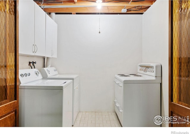 laundry room with washing machine and dryer and cabinets