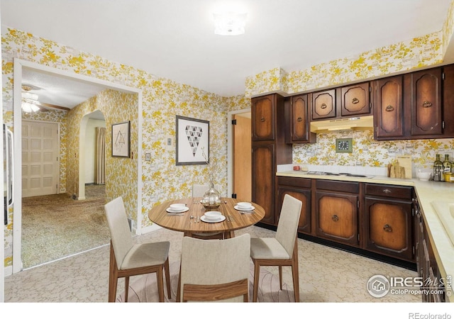 carpeted dining area with ceiling fan