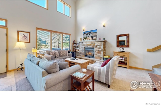 living room with a high ceiling, a stone fireplace, and light tile patterned floors