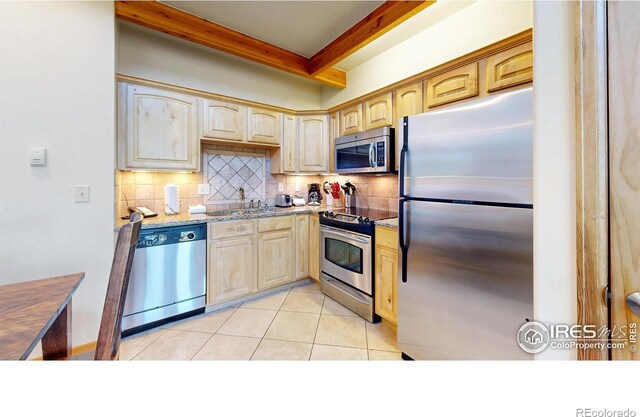 kitchen featuring backsplash, stainless steel appliances, light brown cabinets, and light stone countertops