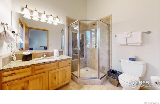 bathroom with tile patterned floors, an enclosed shower, vanity, and toilet