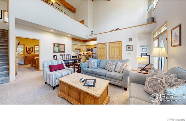 carpeted living room featuring a towering ceiling