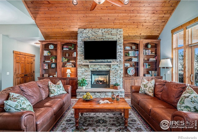 living room with lofted ceiling, wooden ceiling, built in features, a fireplace, and ceiling fan