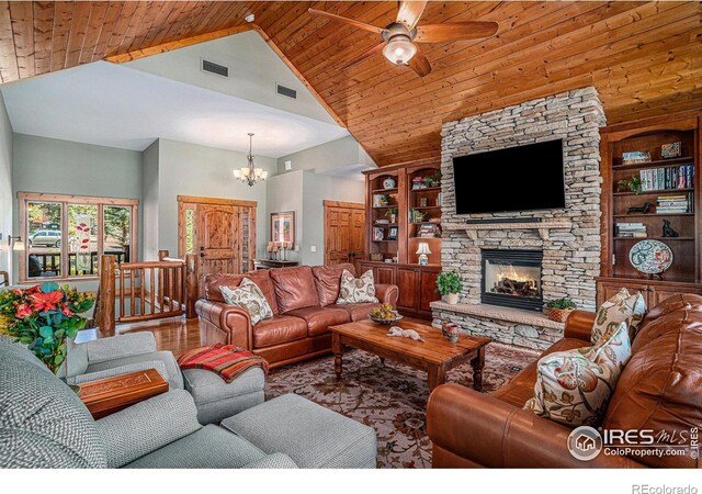 living room with a fireplace, hardwood / wood-style flooring, high vaulted ceiling, and built in features