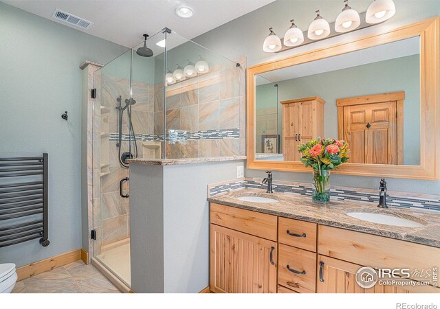 full bathroom with a shower stall, a sink, visible vents, and radiator