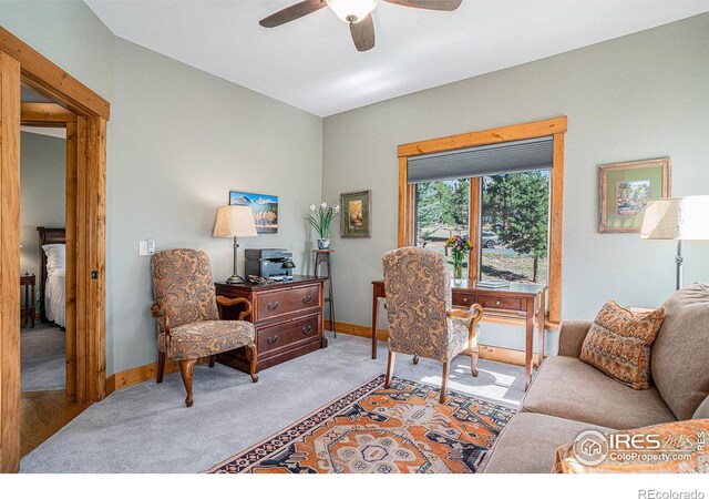 office area featuring a ceiling fan, light colored carpet, and baseboards