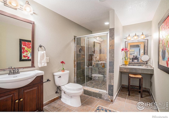 bathroom with a shower with door, vanity, a textured ceiling, and toilet