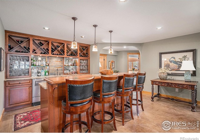 bar featuring dishwasher and decorative light fixtures