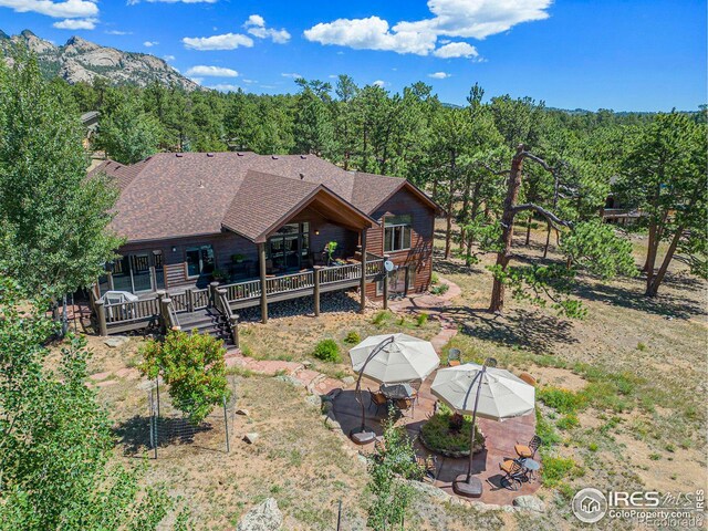 rear view of house featuring a deck with mountain view and a patio area