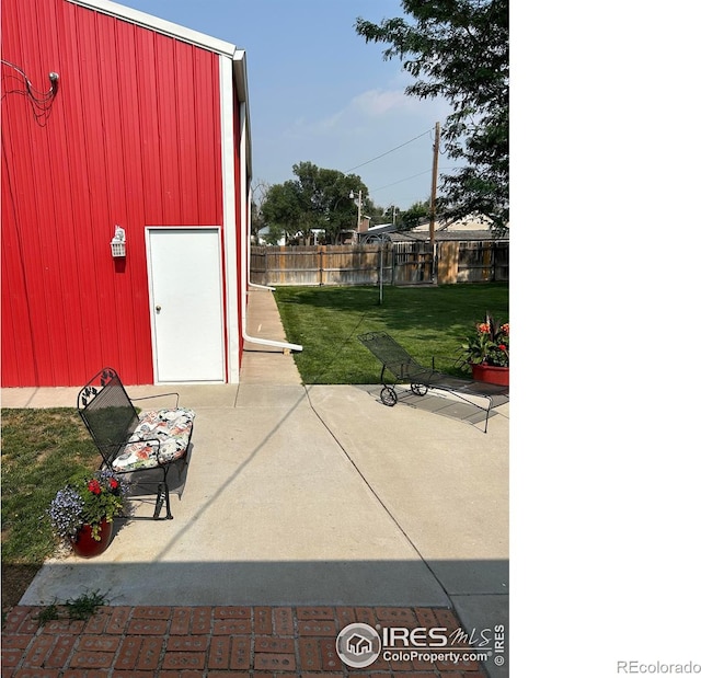 view of patio / terrace featuring an outbuilding and fence