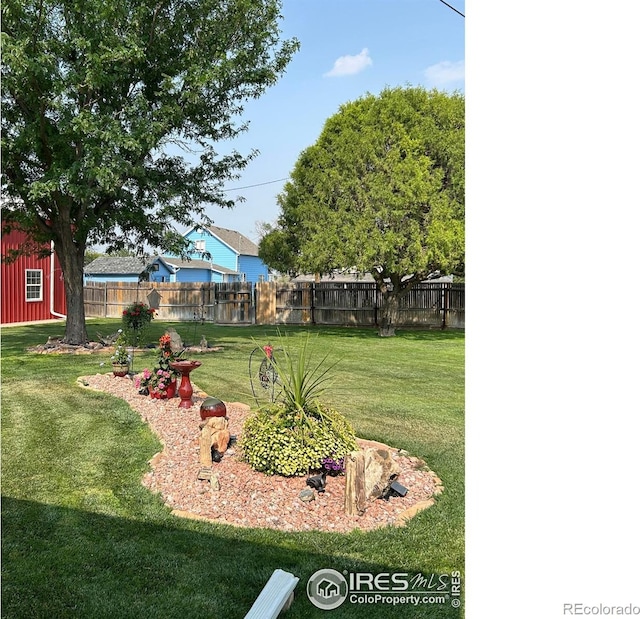 view of yard with fence and an outbuilding