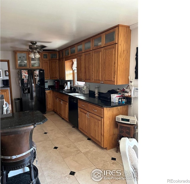 kitchen featuring black appliances, a sink, glass insert cabinets, and brown cabinets