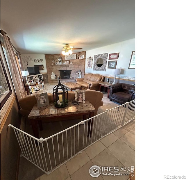 tiled living room featuring a fireplace and a ceiling fan