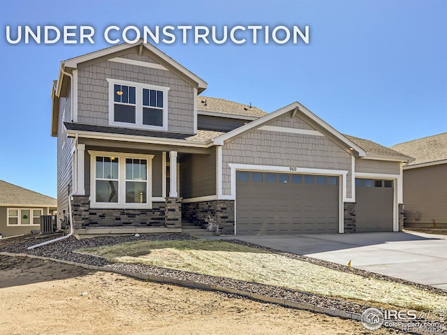 craftsman inspired home with a porch, cooling unit, and a garage