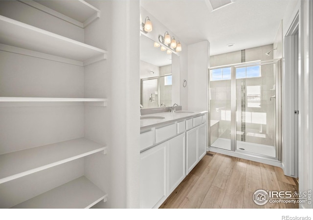 bathroom featuring vanity, hardwood / wood-style floors, and a shower with shower door