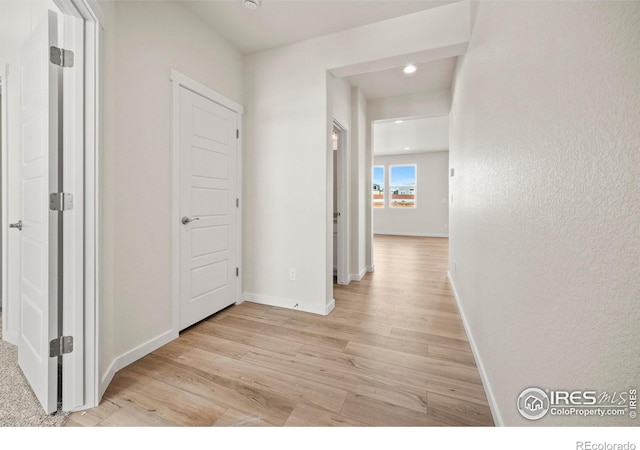 hallway with light hardwood / wood-style floors