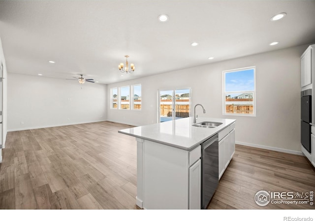 kitchen featuring white cabinetry, an island with sink, dishwasher, sink, and light hardwood / wood-style flooring