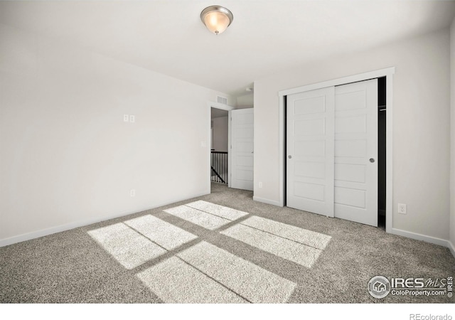 unfurnished bedroom with a closet and carpet