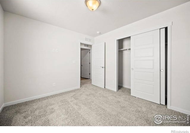 unfurnished bedroom featuring light colored carpet and a closet