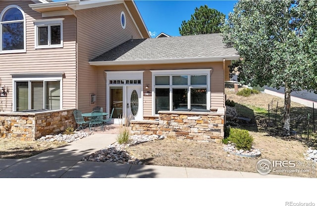 349 Overlook Ln, Estes Park, CO 80517 - view of front of property with stone siding, roof with shingles, and a patio area