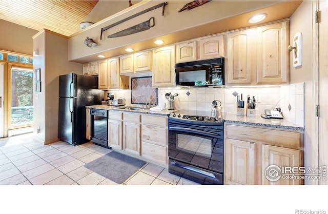 kitchen featuring light stone counters, light brown cabinetry, and black appliances