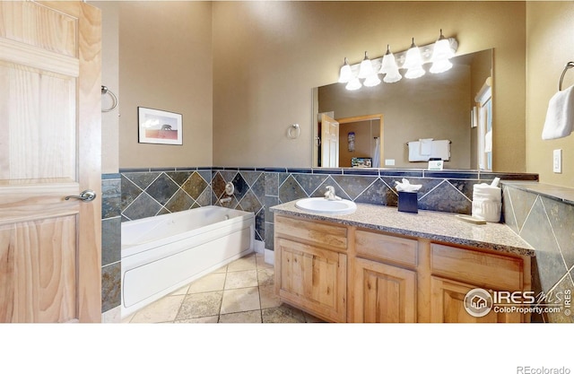 349 Overlook Ln, Estes Park, CO 80517 - full bathroom featuring a garden tub, vanity, tile patterned flooring, and tile walls