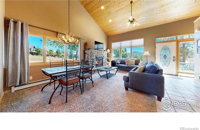 tiled living room featuring a baseboard heating unit, high vaulted ceiling, ceiling fan with notable chandelier, wood ceiling, and a stone fireplace