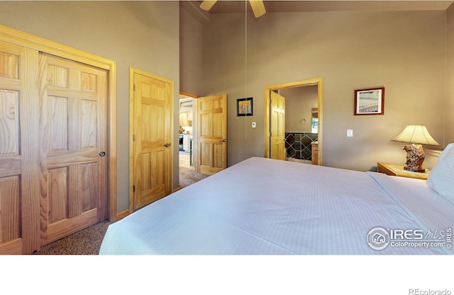 carpeted bedroom with ceiling fan and high vaulted ceiling