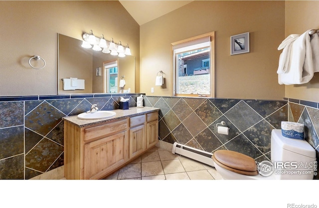 349 Overlook Ln, Estes Park, CO 80517 - bathroom featuring tile walls, a baseboard heating unit, toilet, vaulted ceiling, and vanity