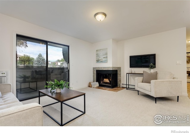 living area with a multi sided fireplace, carpet flooring, baseboards, and a baseboard radiator