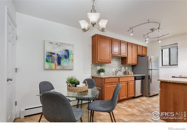 kitchen featuring a baseboard heating unit, brown cabinetry, tasteful backsplash, and stainless steel appliances