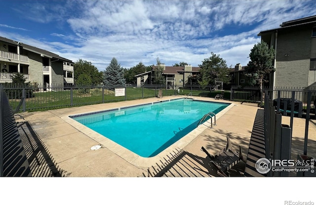 community pool with a yard and fence