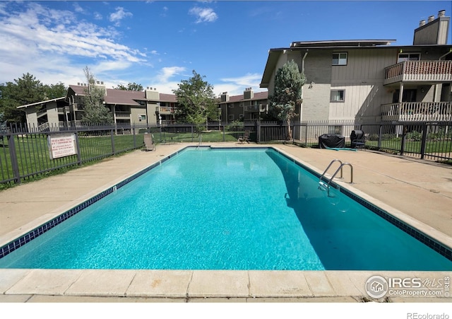 community pool featuring a patio area, a residential view, and fence