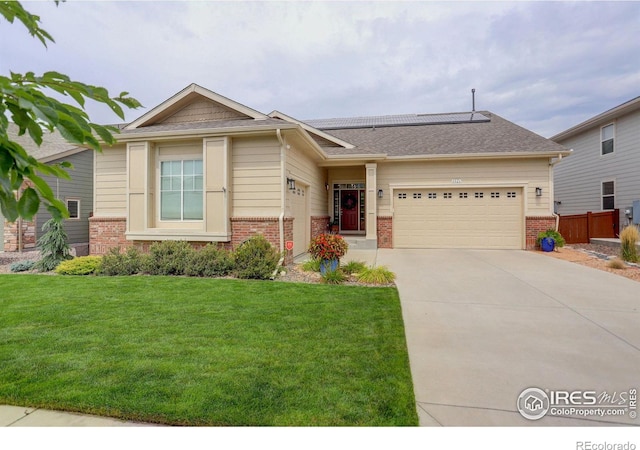 view of front of house with a garage, concrete driveway, brick siding, and solar panels