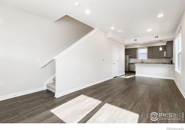 unfurnished living room with dark hardwood / wood-style flooring and sink