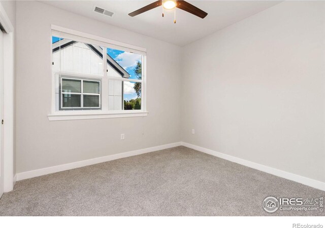 carpeted spare room with ceiling fan