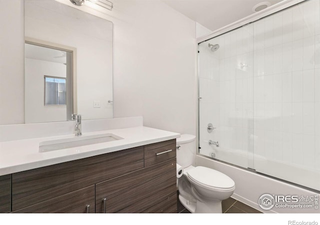 full bathroom with enclosed tub / shower combo, vanity, toilet, and tile patterned flooring