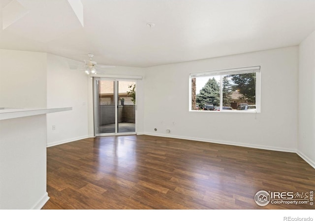 unfurnished room with dark hardwood / wood-style flooring, ceiling fan, and plenty of natural light