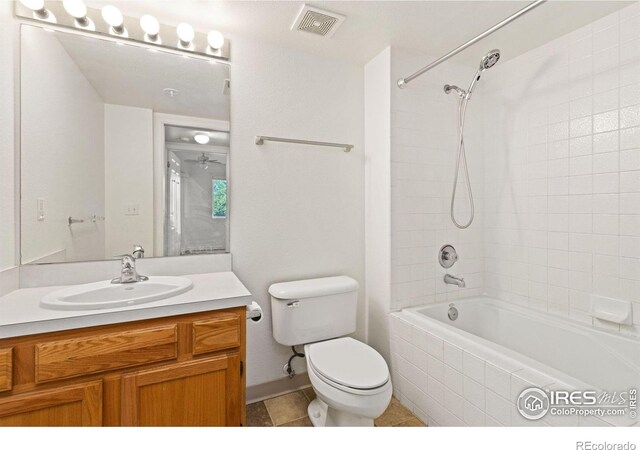 full bathroom with tiled shower / bath, tile patterned floors, toilet, and vanity