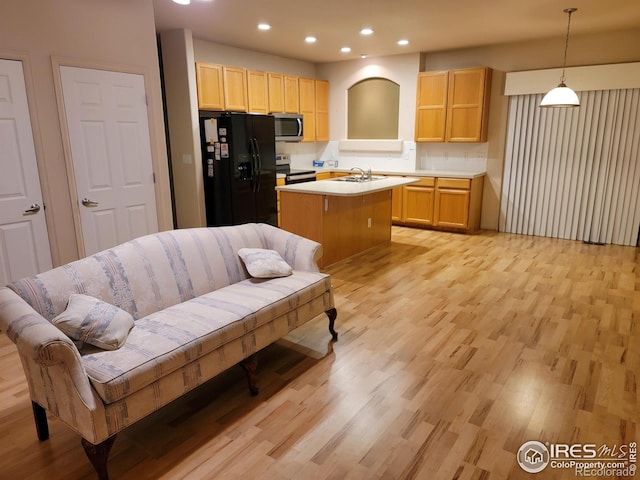 kitchen with tasteful backsplash, pendant lighting, sink, a kitchen island with sink, and appliances with stainless steel finishes