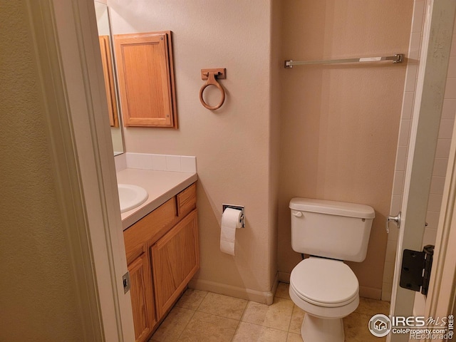 bathroom with toilet, tile patterned floors, and vanity