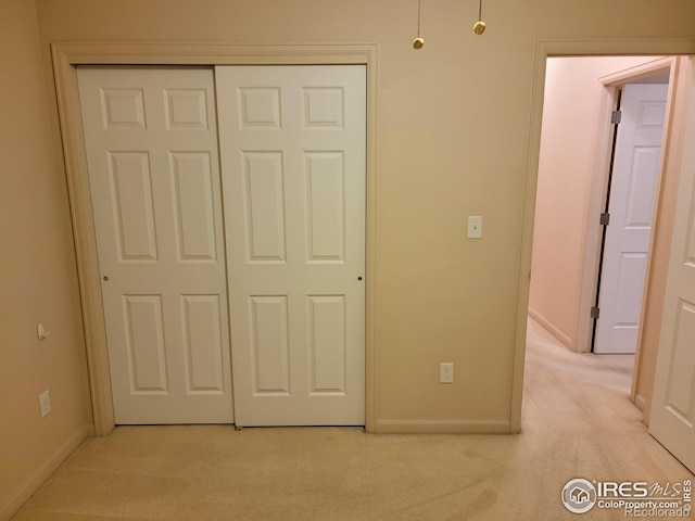 unfurnished bedroom featuring a closet and light carpet