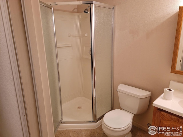 bathroom with toilet, vanity, and an enclosed shower