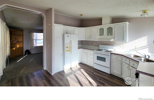 kitchen with sink, white cabinetry, a textured ceiling, white appliances, and dark hardwood / wood-style flooring