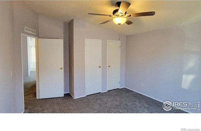 unfurnished bedroom with ceiling fan, lofted ceiling, a textured ceiling, and dark carpet