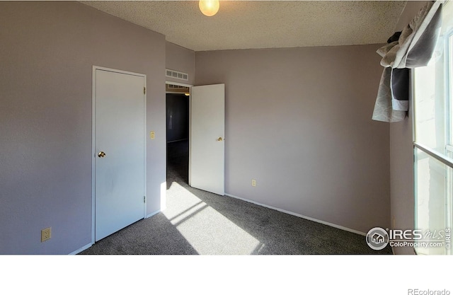 unfurnished bedroom with carpet flooring and a textured ceiling