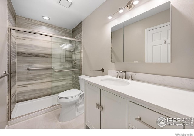 full bathroom featuring toilet, a shower stall, and vanity