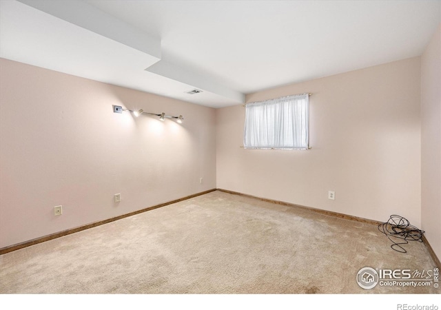 empty room with light carpet, visible vents, and baseboards