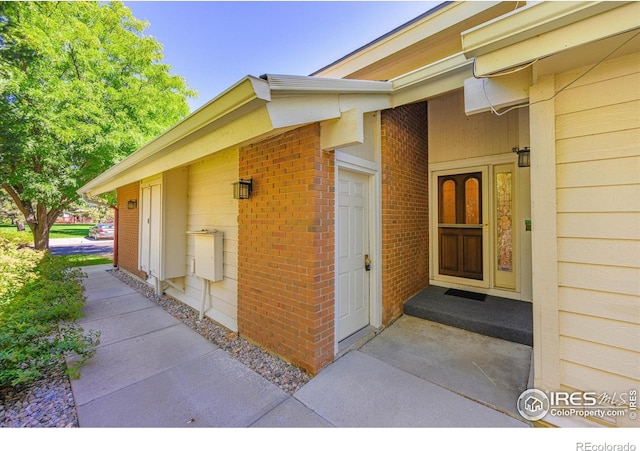 doorway to property with brick siding