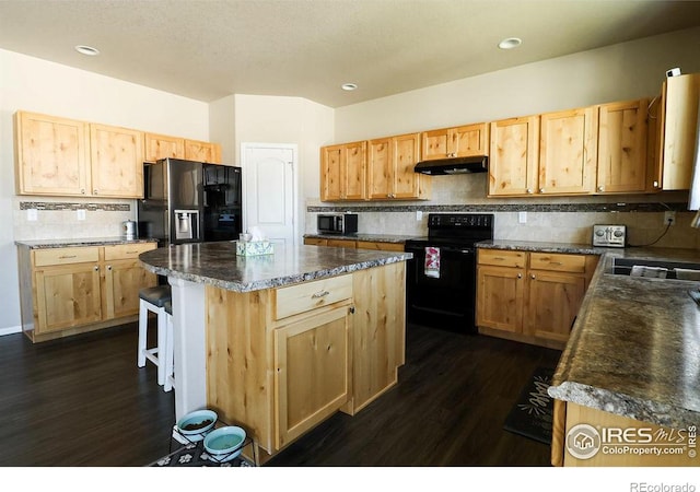 kitchen with dark wood-type flooring, a kitchen island, and black appliances